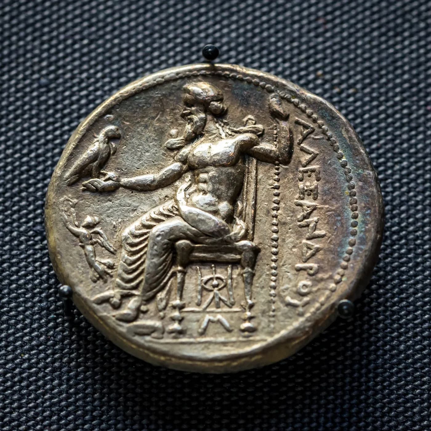 Revers d'une pièce d'argent : Zeus assis sur un trône tient un aigle sur sa main tendue, avec l'inscription grecque ALEXANDROU