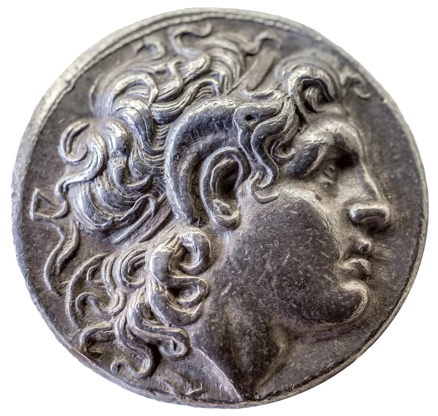 Pièce d'argent montrant de profil la tête d'Alexandre, cheveux bouclés, avec une corne de bélier enroulée au-dessus de l'oreille